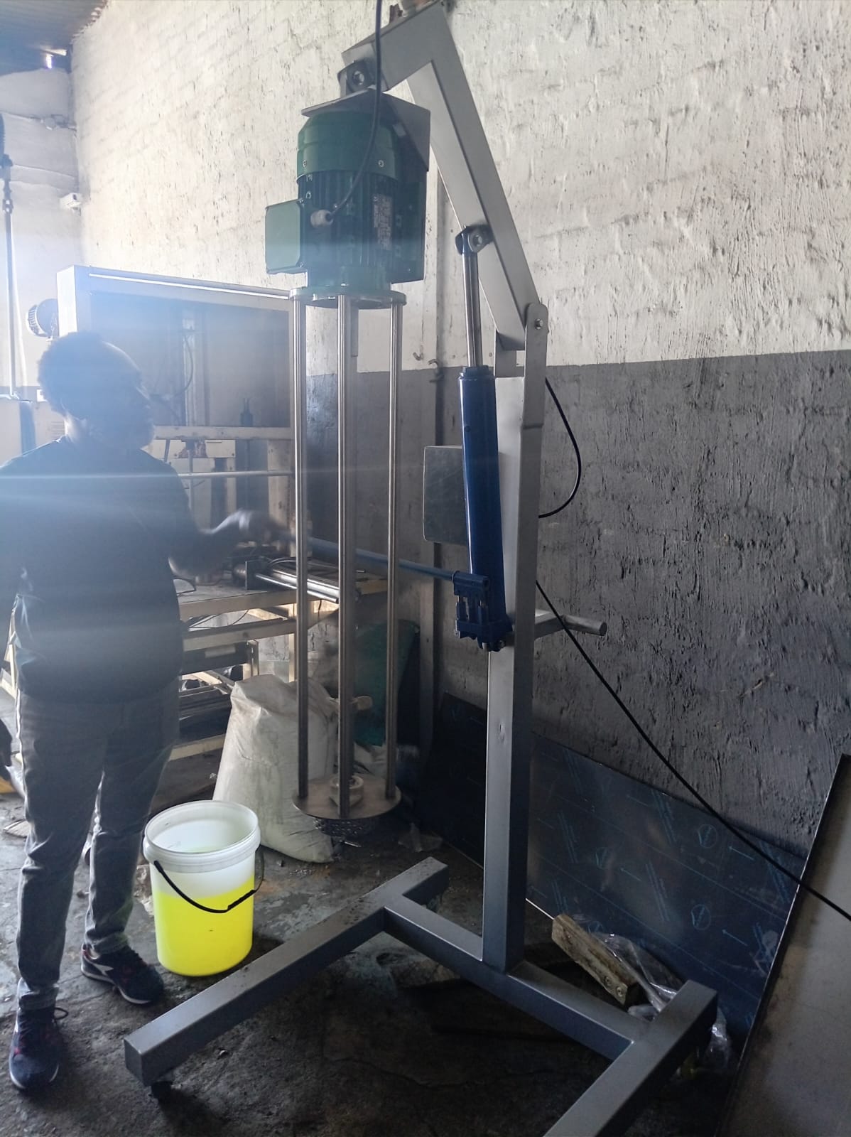 Operator running a Silverson-type homogenizer mixer on a production floor
