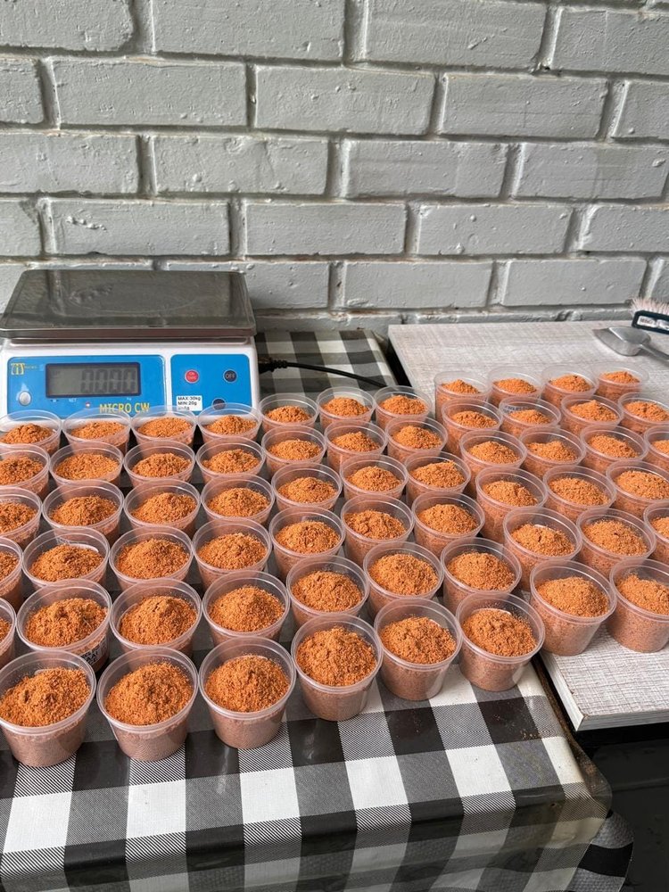 Cups of spice powder filled to a consistent weight, ready for sealing